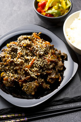 Roasted beef in sauce with spices and sesame seeds in Asian style. Mongolian meat.