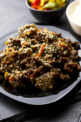 Roasted beef in sauce with spices and sesame seeds in Asian style. Mongolian meat.