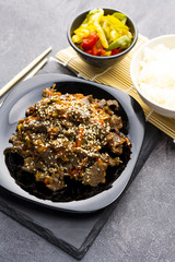 Roasted beef in sauce with spices and sesame seeds in Asian style. Mongolian meat.