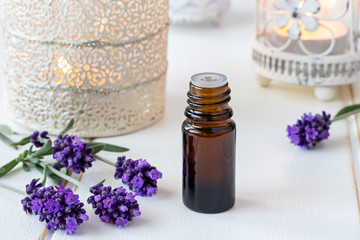 A bottle of essential oil with fresh blooming lavender