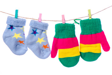 Baby socks  mittens clothespins rope on white background isolation
