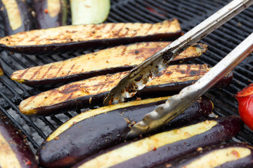Close-up lices of eggplant are grilled. Open fire kitchen. BBQ Restaurant. vegetables on bbq fireplace. Street food, picnic concept