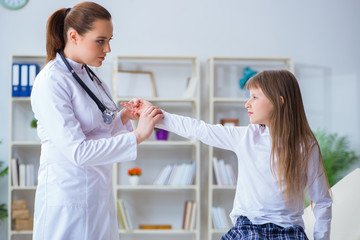 Fototapeta premium Female doctor pediatrician checking girl