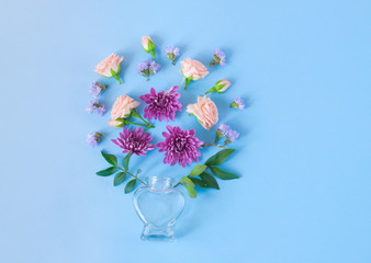 Perfume bottles with flowers on a blue background.  cosmetics, fragrance collection. Flat lay, minimalism 