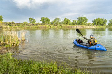 paddling a packraft on a calm lake