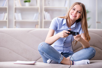 Young female student playing games at home