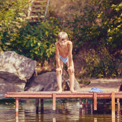 Portrait of healthy young boy resting after swimming, image with square aspect ratio and warm toning