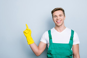 Professional housekeeper present index up empty blank place person concept. Portrait of cheerful with beaming toothy smile excited confident guy pointing up with forefinger isolated on gray background