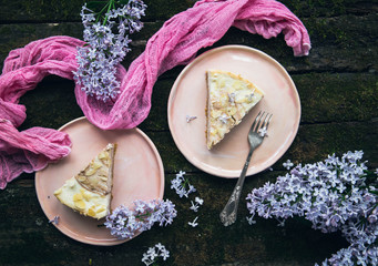 cheesecake and lilac on a wooden table