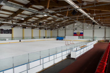 indoor ice arena; ice combine preparing ice; on the wall of the flag of the Russian Federation. General view - Powered by Adobe