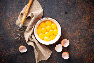 Bowl with eggs yolks and whisk