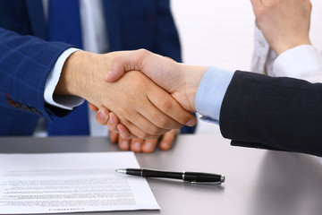 Business people shaking hands, finishing up a papers signing. Meeting, contract and lawyer consulting concept