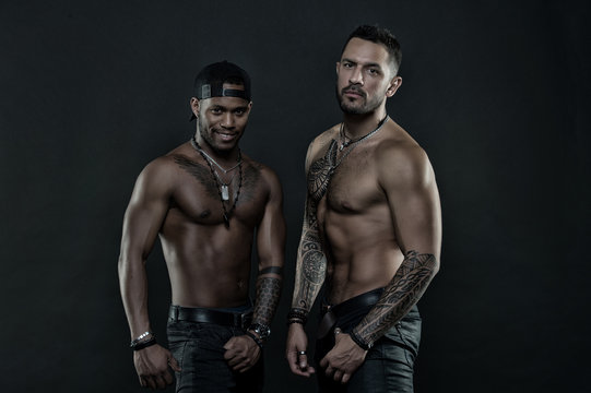 Sportsmen with muscular chest and belly. African and hispanic men with sexy bare torso. Men with fit tattooed body. Fashion models with tattoo in jeans. Sport with fitness and bodycare, vintage filter
