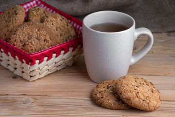 Oatmeal cookies with sunflower seeds near cup of tea.