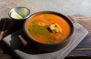 Marmitako soup in a ceramic bowl on a wooden board