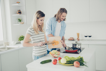Obraz na płótnie Canvas Side view portrait of attractive partners preparing dinner together keeping healthy lifestyle enjoying weekend vacation holiday together. Weightloss fitness concept