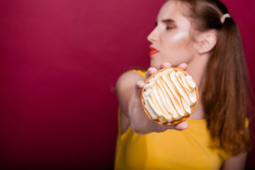 Adorable dieting brunette woman refusing tart cake with butter cream. Empty space