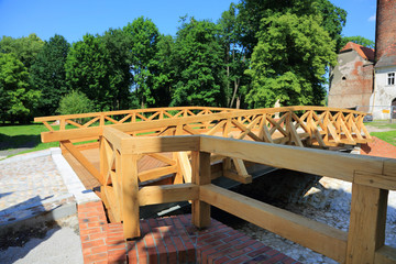 Nowy most konstrukcji drewnianej nad fosą wokół starego zamku. - obrazy, fototapety, plakaty