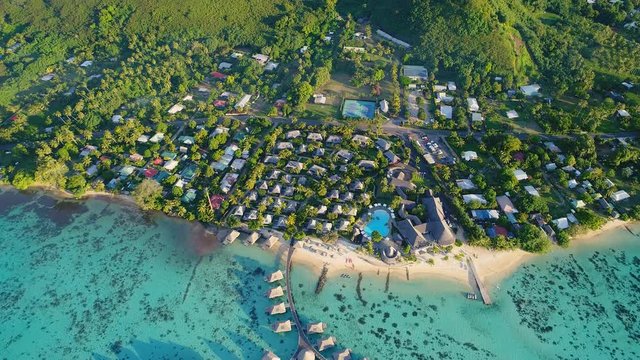 Aerial view of tropical paradise of Moorea island, turquoise crystal clear water of scenic blue lagoon, over water bungalows on foot of Mount Rotui - South Pacific Ocean, French Polynesia landscape