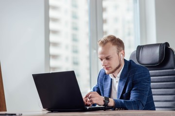 Fototapeta premium Businessman office worker enjoys a laptop in a modern workplace. smart watch .