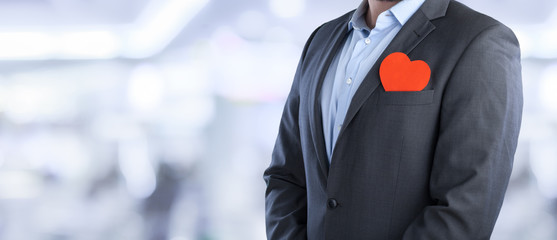 Businessman with heart on city background