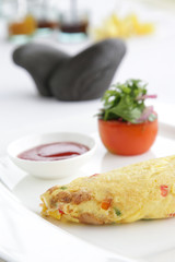 Eggs omelette served with tomato on the restaurant table, hotel breakfast