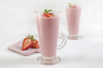 Delicious strawberry milk shake in a two glass composition