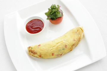 Eggs omelette served with tomato on the restaurant table, hotel breakfast
