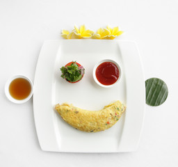 Eggs omelette served with tomato on the restaurant table, hotel breakfast
