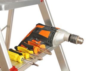 Close-up of the metal ladder with drill, screwdriver and pliers isolated on white background
