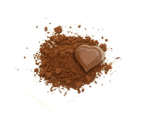 Chocolate heart-shaped candy on a cocoa powder isolated on white.
