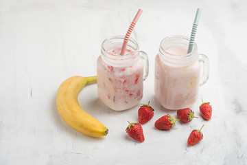 Banana and strawberry yogurt with strawberries and bananas on a light background