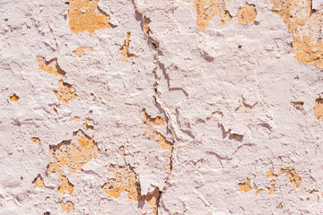 Old flaky paint peeling off on old wall, cracks and scrapes on the surface