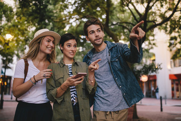 Friends using smartphone for find a way in city