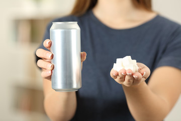 Woman hands holding a soda drink can and sugar cubes