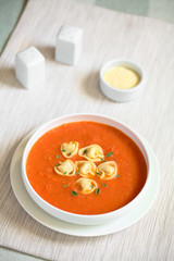 Hausgemachte frische Tomatencremesuppe mit Tortellini und frische Oreganoblätter, fotografiert mit natürlichem Licht (Selektiver Fokus, Fokus in die Mitte der Suppe)