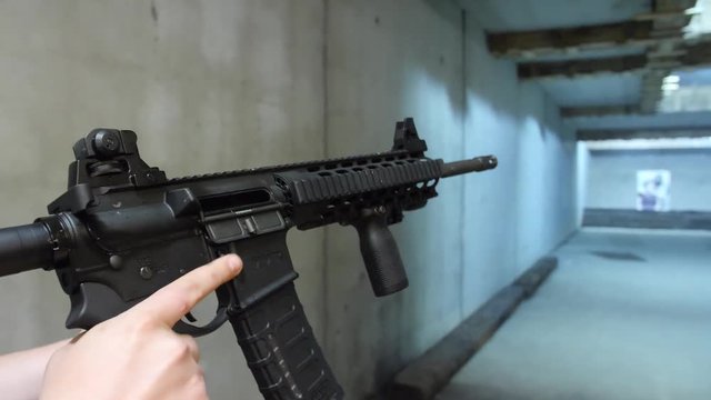 White male adult demonstrates how to load and reload an assault rifle at a shooting range SLOW MOTION