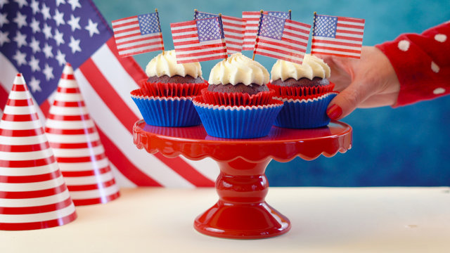 Red white and blue theme cupcakes with USA flags for Independance Day or USA theme party food.