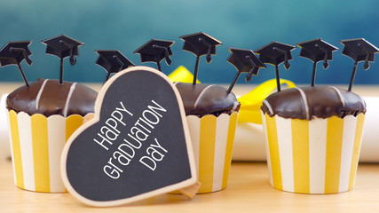 Yellow and blue theme graduation party cupcakes with cap hats toppers and decorations.
