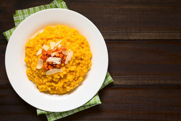 Hausgemachter Karottenrisotto zubereitet mit pürierten Möhren, serviert mit gerösteten Möhren und Käse, fotografiert mit natürlichem Licht (Selektiver Fokus, Fokus auf das Risotto)