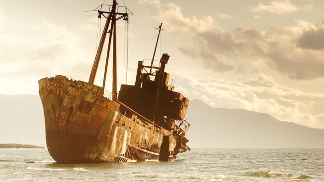 An old abandoned shipwreck, wrecked boat sunken ship stand on beach coast.  Accident at sea 4K