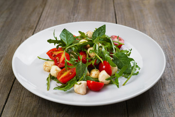 Caprese salad with tomatoes, basil and mozzarella cheese. Restaurant serving of delicious side dish with fresh vegetables. Mediterranean and Italian traditional cuisine, appetizer, menu concept