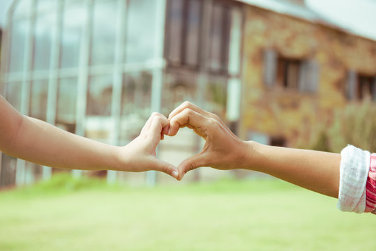 Hand Mom And Child On Heart-shaped Home Background Blurred, Natural Tones Vintage Style. Show The World You Love Love Family Between Two People.Let's Stay Together Happy Mother's Day,