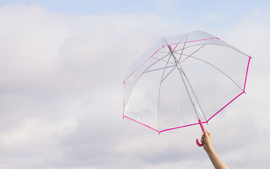 Hand holding transparent umbrella outdoor