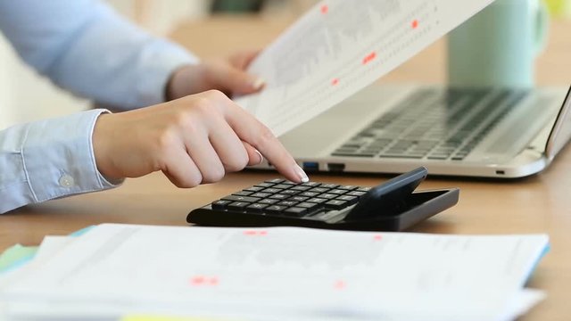 Close up of an accountant hands calculating with a calculator on a desk