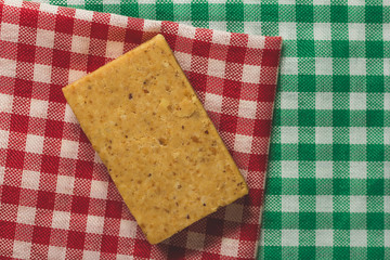 Pacoca is a candy with peanuts from Brazil. Sweet food of Festa Junina, a typical brazilian party. Snack over green and red plaid fabric.