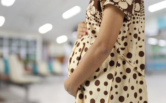 Belly of pregnant woman blur hospital backdrop and have copy space.