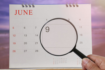 Magnifying glass in hand on calendar you can look ninth day of month,Focus number nine in June.