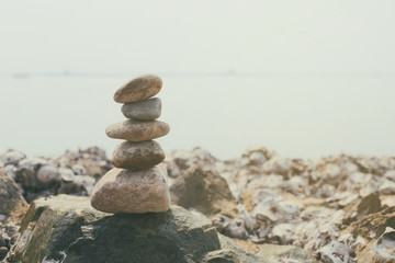 Fototapeta premium Stacked of stones on the summer coast in calmness and relaxation concept.
