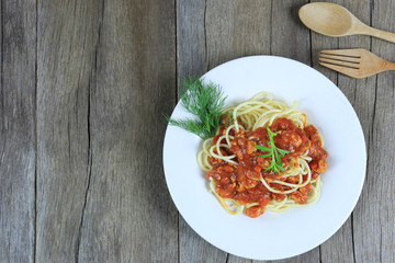 Spaghetti with tomato sauce in a white dish on wooden floor background and have copy space.